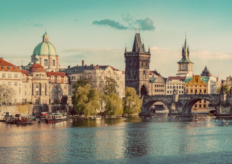 Panoramski pogled na Karlov most i arhitekturu Praga sa obala reke Vltave, poput platna oživljene istorije.