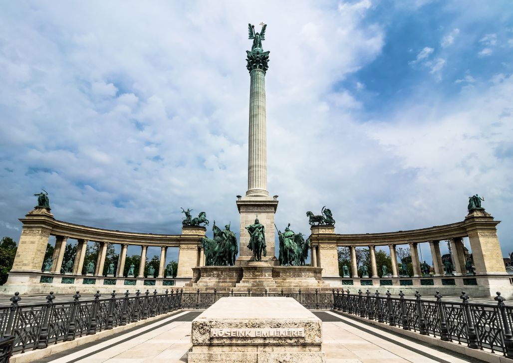 Spomenik i skulpture na Trgu heroja u Budimpešti, pod dramatičnim oblacima.