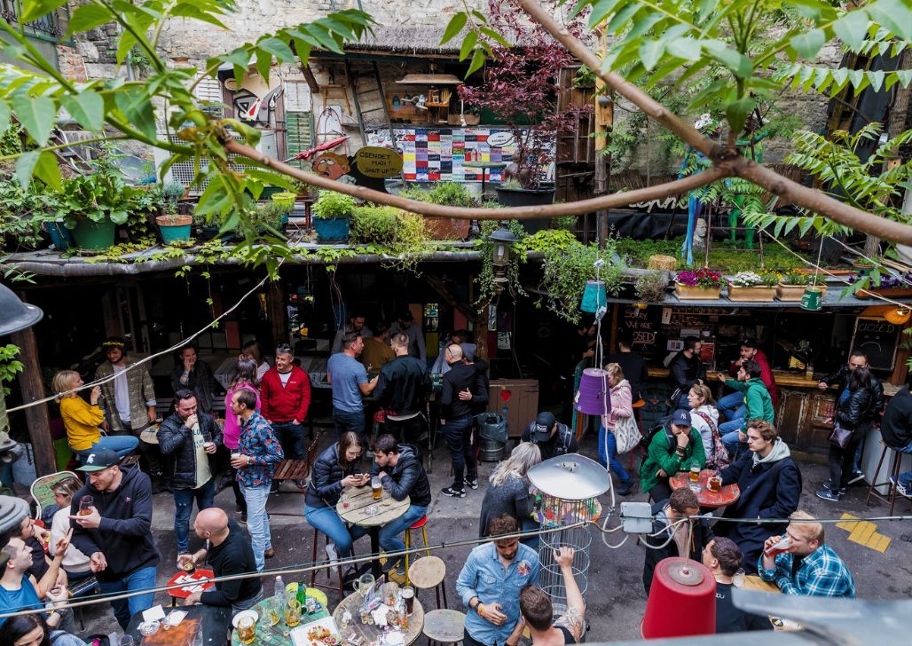 Gomila ljudi druži se u ruin baru Doboz, boemski dekor i zelenilo unutrašnjeg dvorišta.