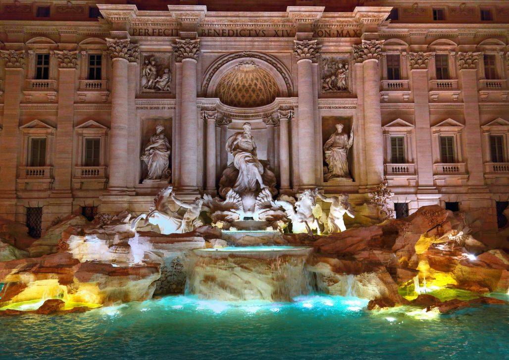 Fontana di Trevi zasijana svetlom noću.
