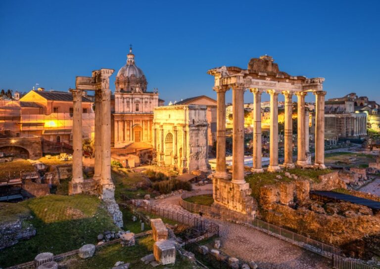 Rimski forum pri sumraku sa osvetljenim ruševinama. Putovanje u Rim