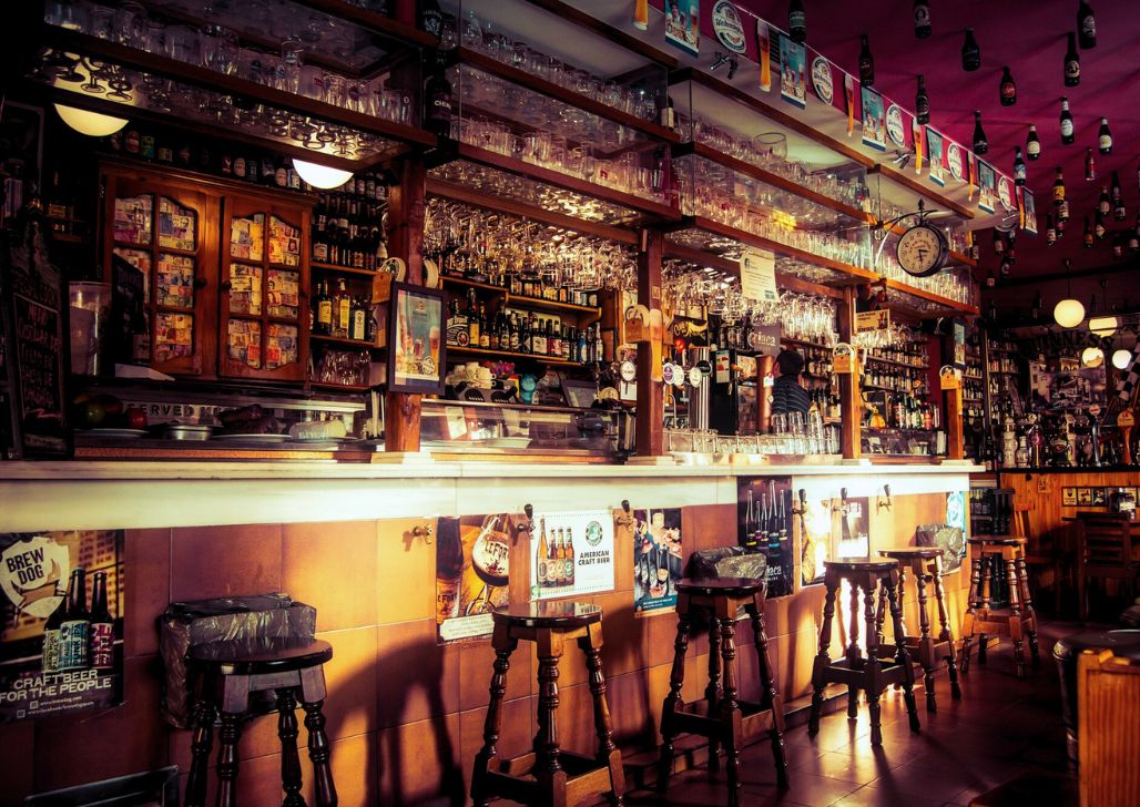 Unutrašnjost puba u Budimpešti sa starinskim ukrasima i bogatim izborom pića.